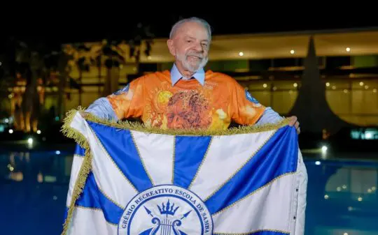 Lula chega à Sapucaí cercado de ministros e vê desfile que encena prisão e impeachment